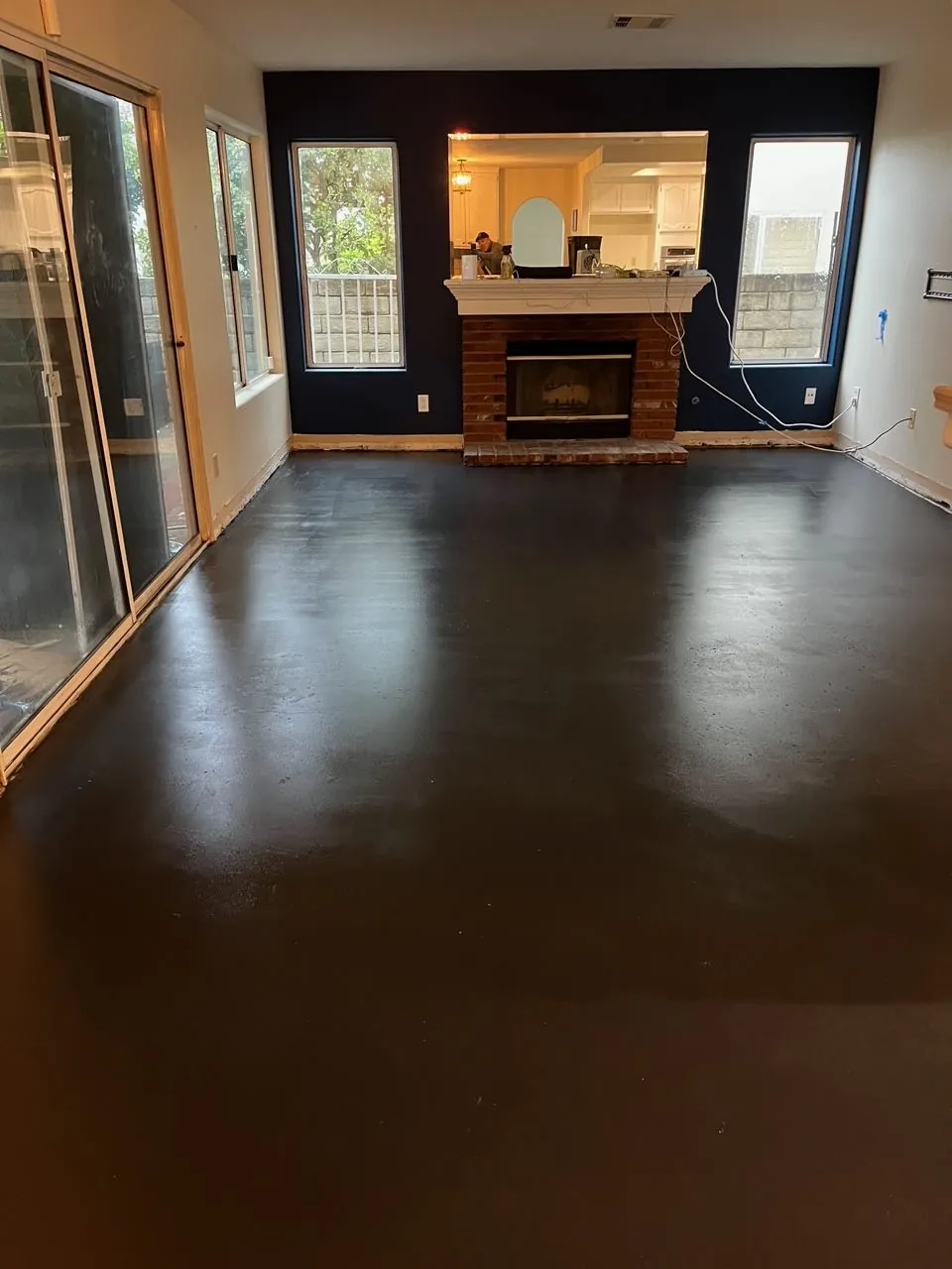 Dark finished concrete floor in a living room with a fireplace