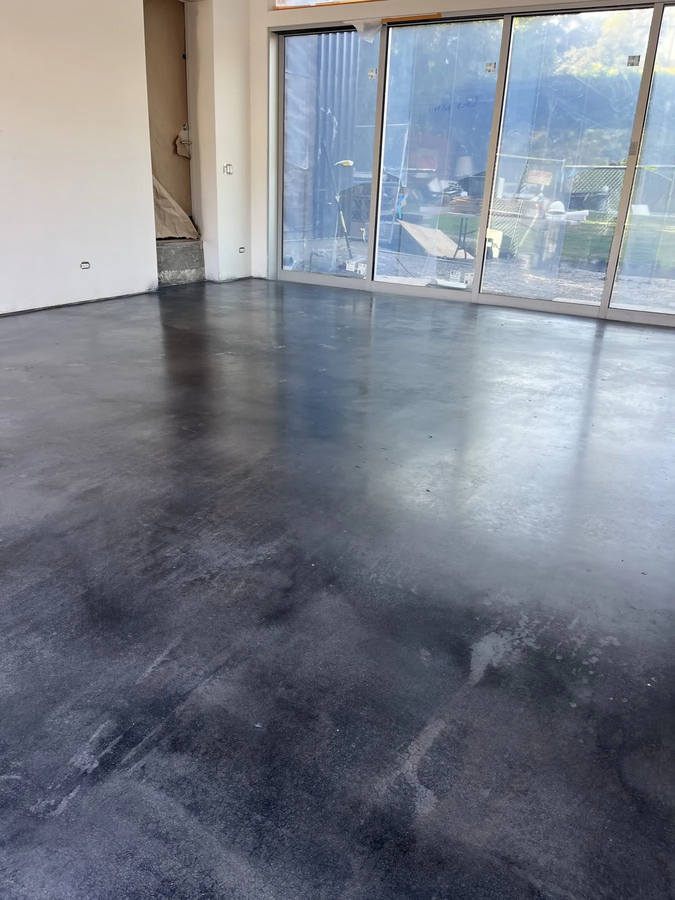 Dark metallic epoxy floor in a room with glass doors