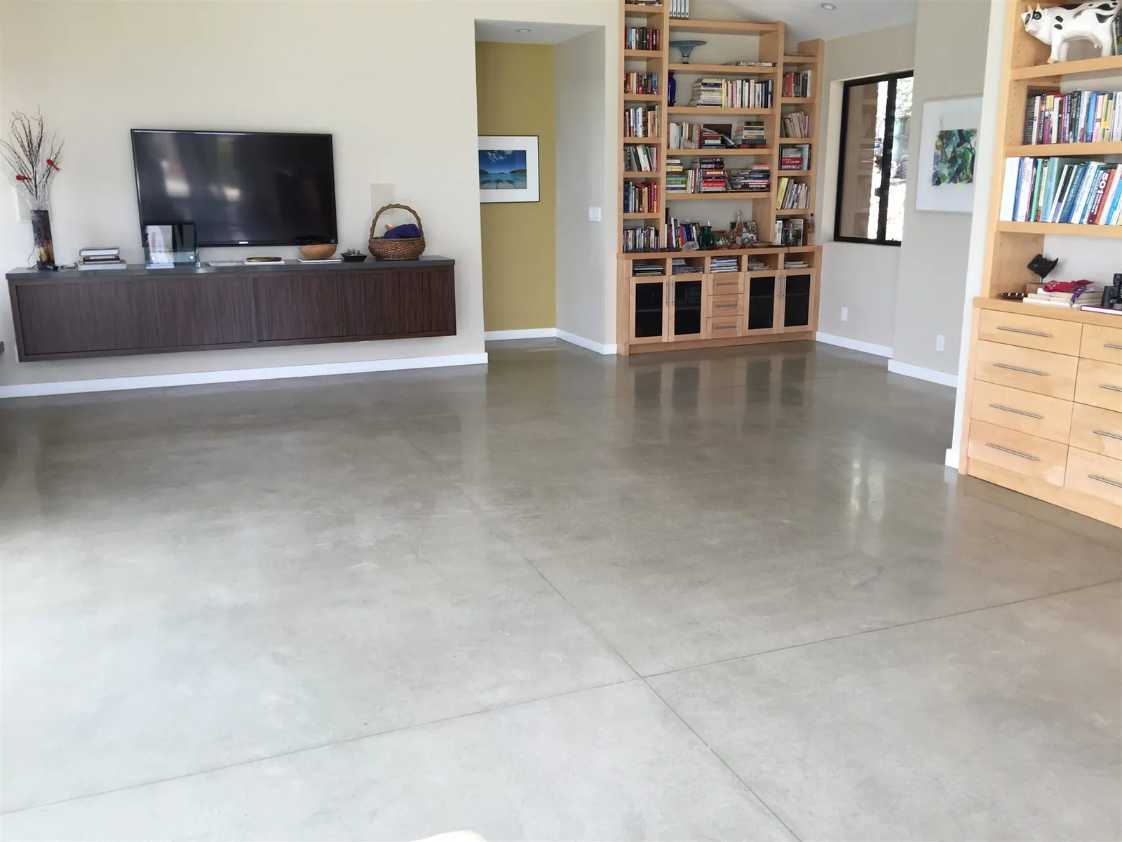 Polished concrete floor in a family room with built-in shelves