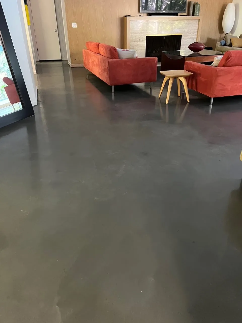 Dark polished concrete floor in a living room with a fireplace