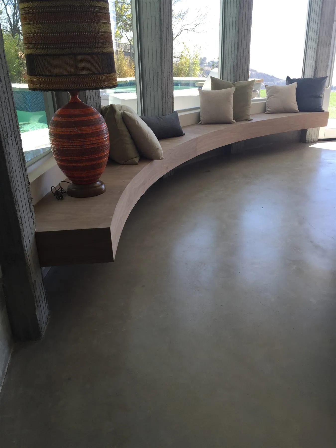 Satin polished concrete floor by a window seat in a hillside home