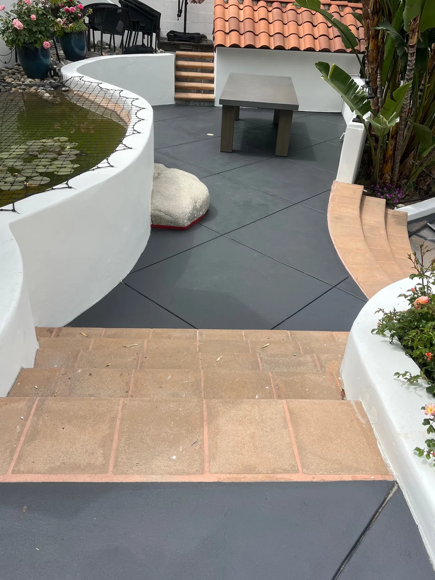 Dark grey stained concrete patio and steps at a Spanish-style home
